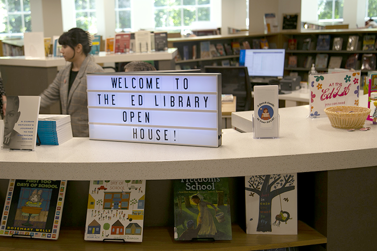 A marquee sign sits on the library reference desk and reads, Welcome to the Ed Library Open House!