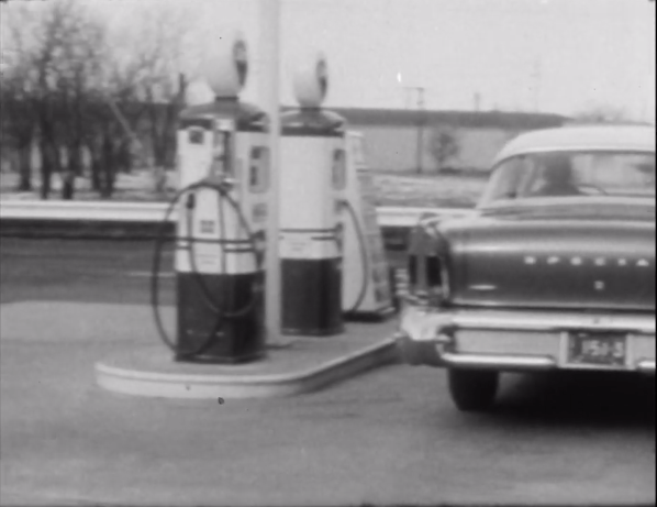 Still showing gas pumps and back of an old car