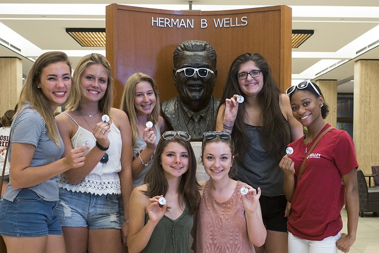 Herman B House Party attendees with bust of Herman B Wells in Wells Library 2015