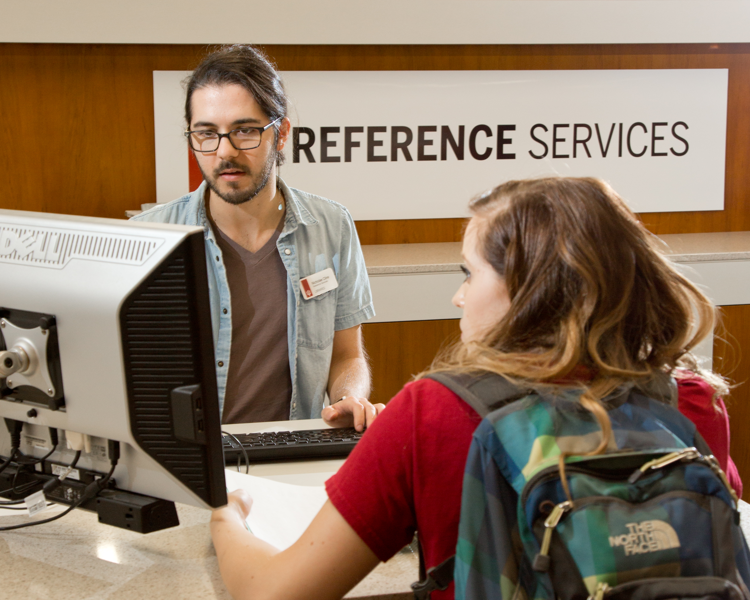 Librarian assisting a student at the Reference Services desk