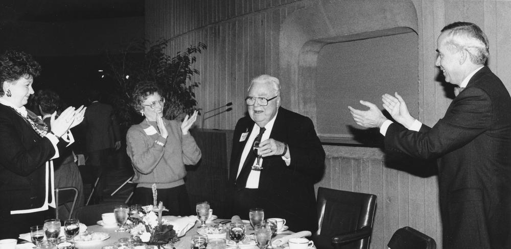 Photograph of Herman B Wells being congratulated at banquet