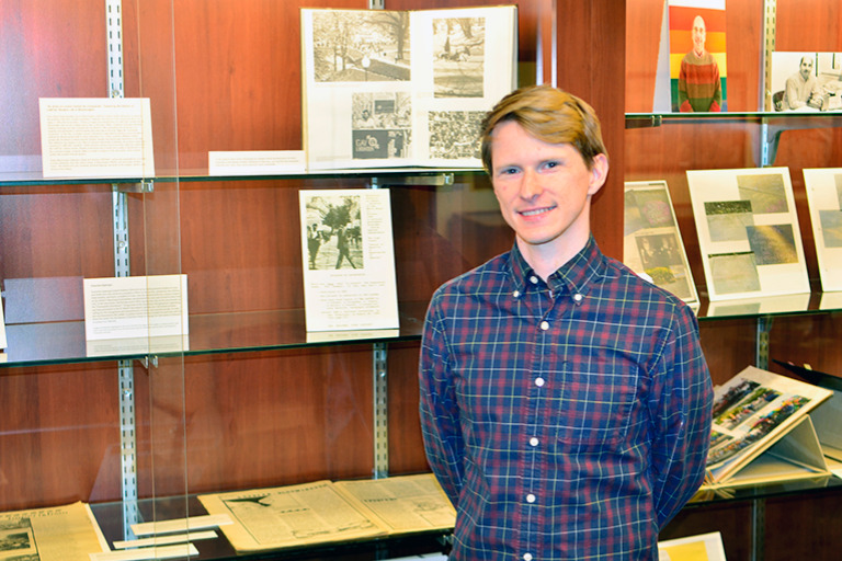 Exhibit curator Kennedy Jones poses in front of a display case.