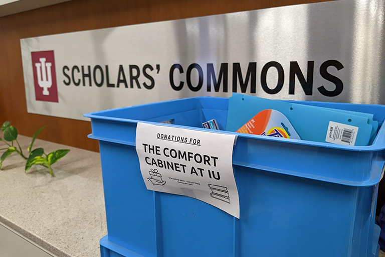 Blue plastic bin with sign "The Comfort Cabinet at IU"