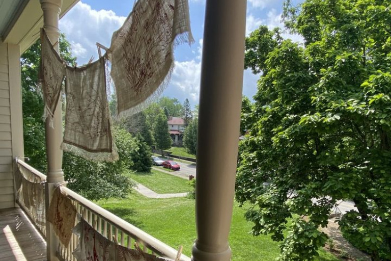 Textiles hanging from a clothesline on the porch of the Wylie House.