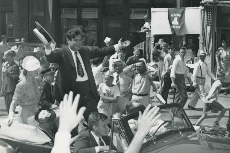 Wendell Willkie, standing in the back of a convertible, waving to the crowd during a campaign visit.