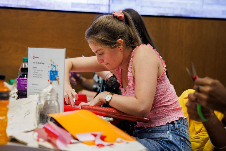 A student has a look of concentration on her face while working on a craft project.