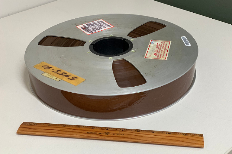 A reel of 2-inch Quad Tape on a tabletop with a ruler nearby