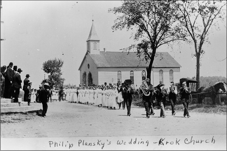 A polka band leads a wedding party down a road outside a church in rural Wisconsin.