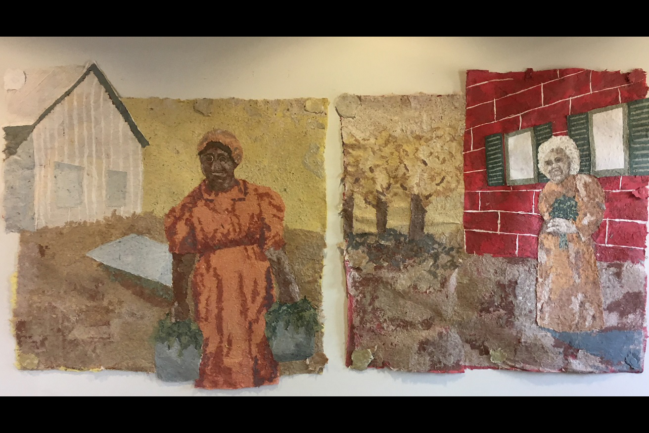 A photo of two wall murals showing women in the gardens of Wylie House