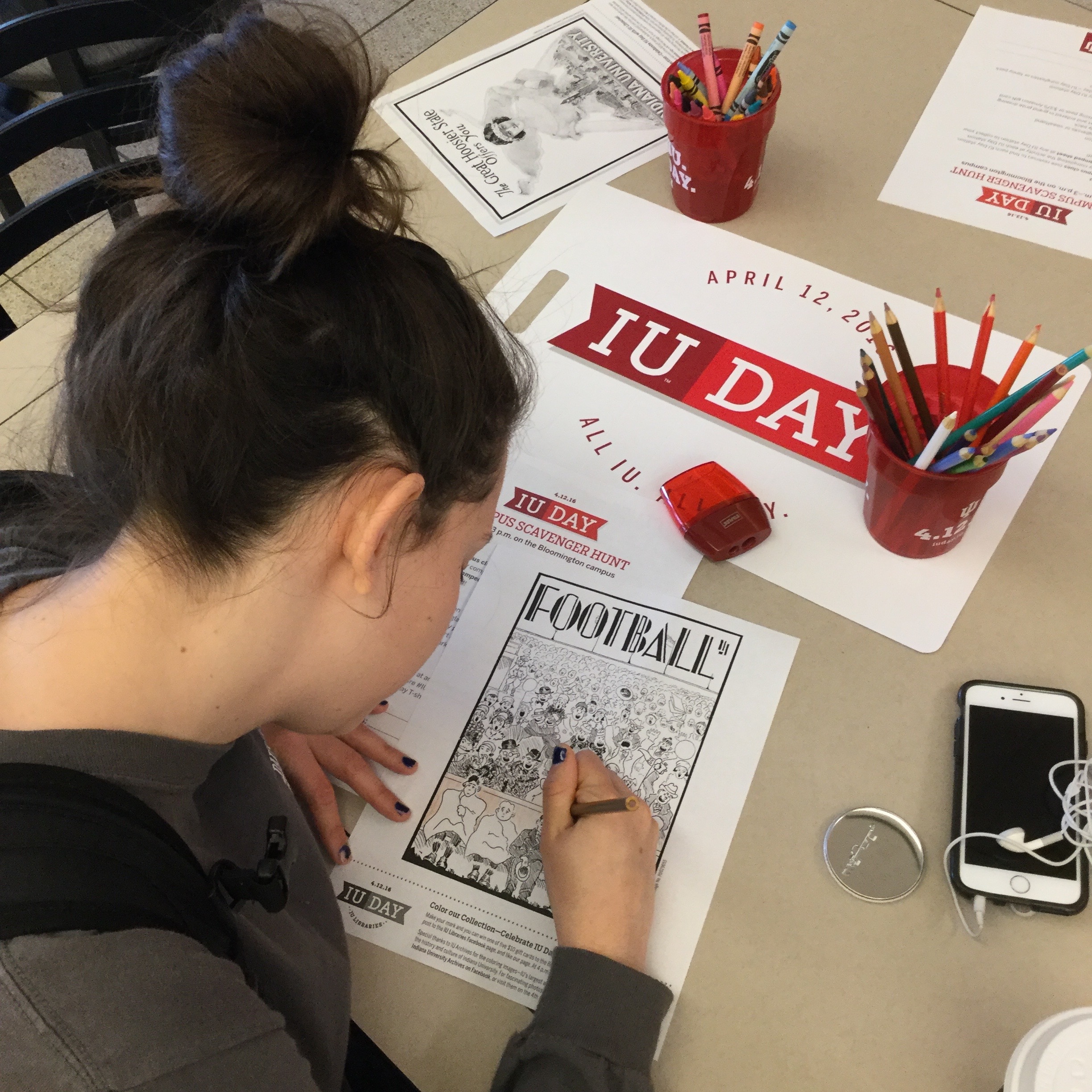student working on a coloring page depicting IU Football 