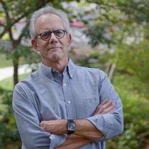 Portrait of professor Greg Waller of IU Media School, outdoors with arms crossed.