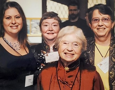 Four broad faces of women, obviously related, beam at the camera. The one in front is short and older. The youngest is behind her to her right. The other two are middle aged.