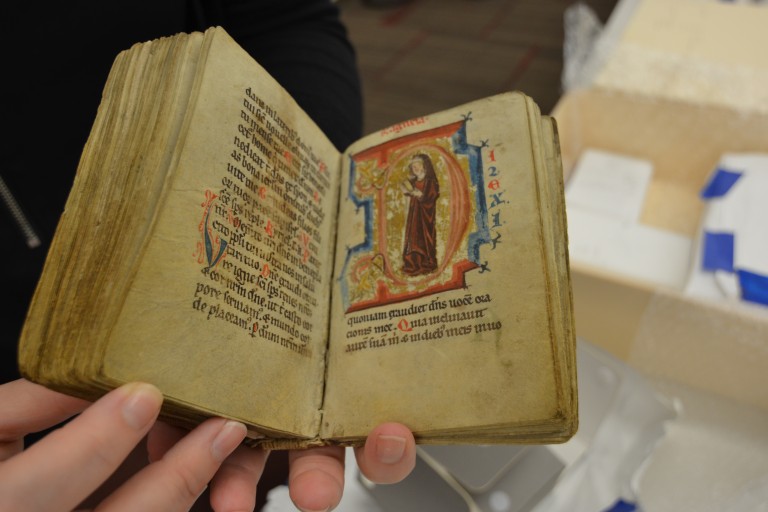 A small Medieval codex with an illuminted picture of a monk in the letter "D."