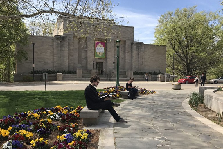 Photograph of two people reading books outside the Lilly Library.