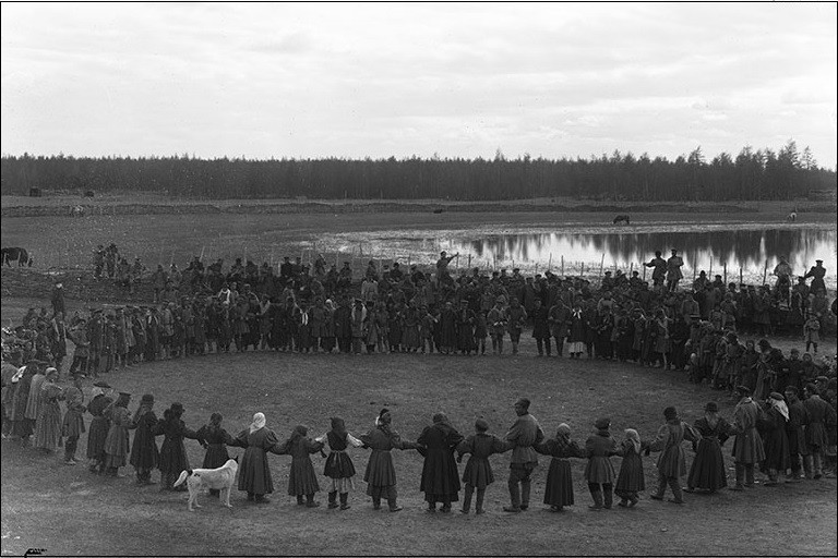 A large group of Yakuts stand in a circle and dance at a festival.