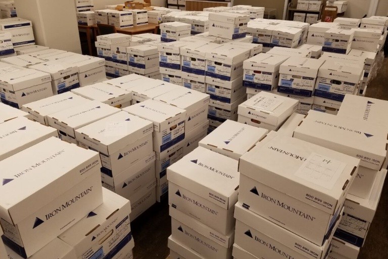 A view of the portion of the Kripke collection. Numerous white boxes stacked on top of each other. 