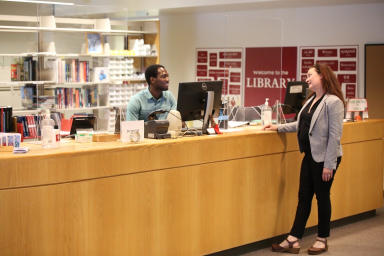 Image of student worker working at circulation desk in Education Library