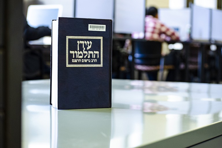 Image of a Hebrew book on a table at Wells Library