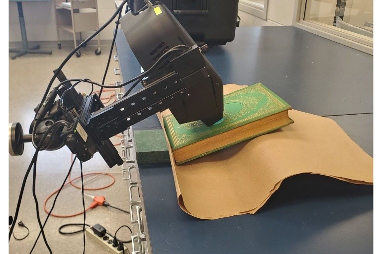 portable XRF instrument taking a reading from a book within the Lilly Library collections suspected and now proven to contain emerald green pigment.