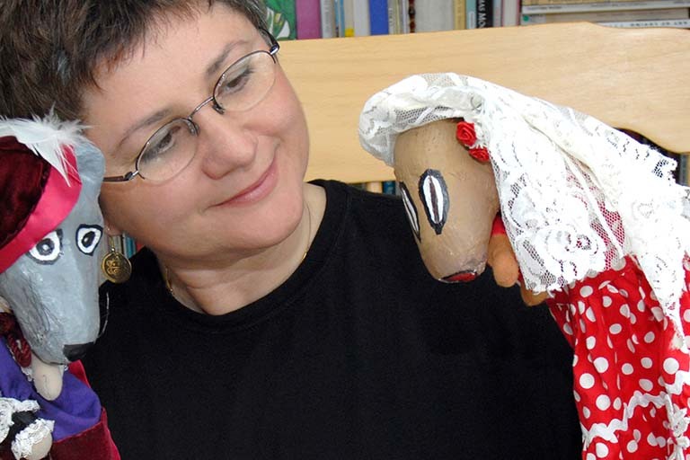 Person with a puppet in each hand.