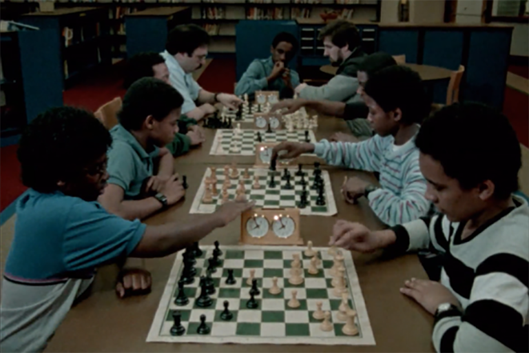 Image from the film Masters of Disasters, showing school children playing chess.