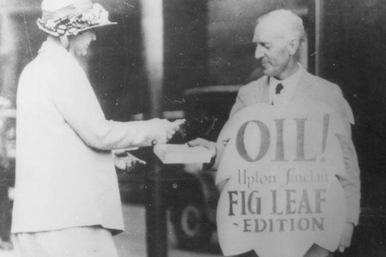 Photograph of Upton Sinclair selling the "fig-leaf" edition of his novel, Oil!