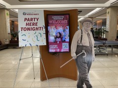On either side of a kiosk displaying a Welcome Week slide we see a sign that says "Party Here Tonight!" and a near-life-size cardboard cutout of Herman B Wells.