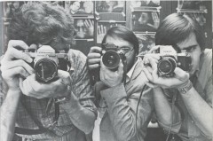 Black and white image of 3 men looking through cameras