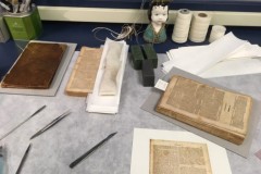 A book on a conservator's bench, in the process of being repaired.