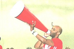 College-age black male is speaking into a large cheerleader megaphone