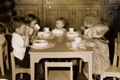 Great Depression era children sitting around a wooden table sharing a meal